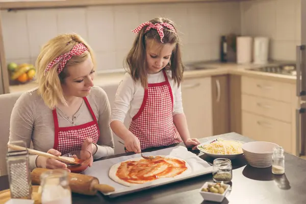 부엌에서 피자를 만드는 어머니와 브러시와 반죽에 케첩을 — 스톡 사진