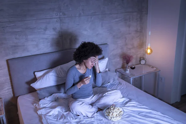 레이스 침대에 잠옷을 팝콘을 Tv에 영화를 머리를 — 스톡 사진