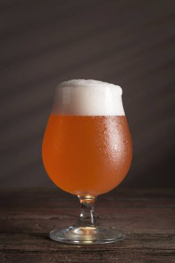 Kırsal bir ahşap masada bir bardak soğuk greyfurt birası.