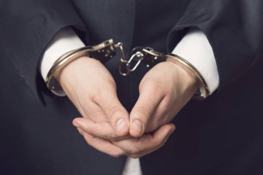 Kelepçeli takım elbiseli bir iş adamı tutuklandı. Seçici odak