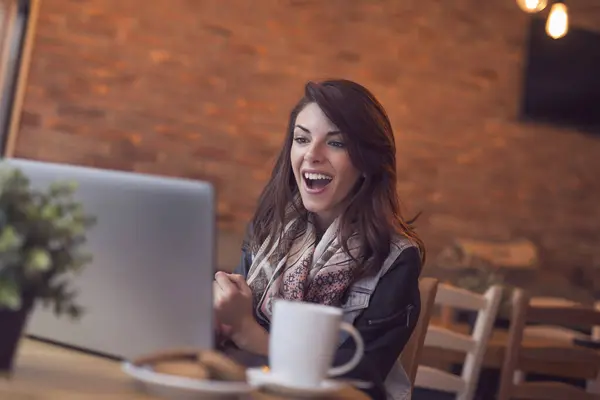 カフェに座り コーヒーを飲み ラップトップコンピュータを使っている若い女性 — ストック写真
