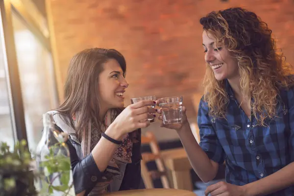 两个女孩坐在咖啡店里 用薄荷叶喝解毒水 玩得很开心 注意右边的那个女孩 — 图库照片