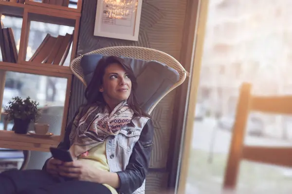 Mooie Jonge Vrouw Zittend Een Café Met Een Smartphone Kijkend — Stockfoto