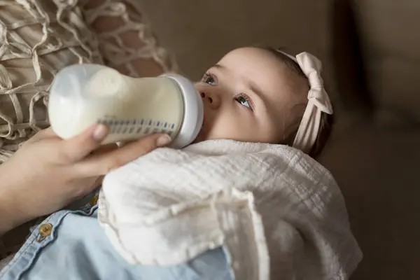 母亲把女婴抱在怀里 用奶瓶喂她 — 图库照片