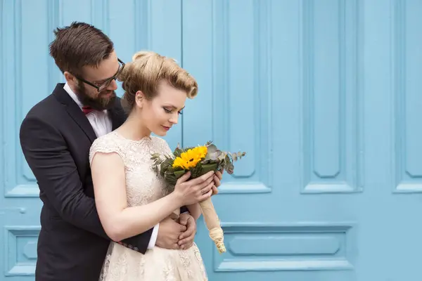 Couple Nouvellement Marié Étreignant Debout Côté Une Porte Bois Bleu — Photo