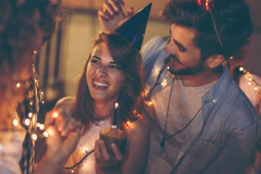 Bir grup genç arkadaş binanın çatısında doğum günü partisi veriyor, şarkı söylüyor ve mum üflüyorlar. Doğum günü kızına odaklan.