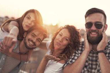Bir grup genç arkadaş yaz tatili çatı partisinde eğleniyor. Öpücük gönderen kıza odaklan.