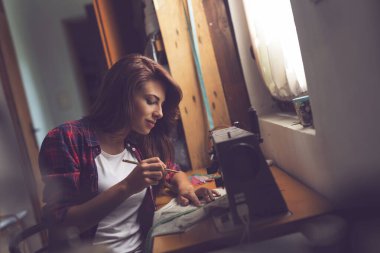 Tişörtünün uzunluğunu ölçüp işaretleyen genç bir terzi.