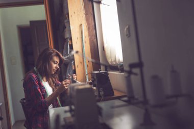 Genç terzi elle dikiş dikiyor.