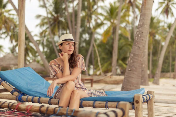トロピカルエキゾチックなビーチリゾートでリラックスし サンベッドに座って休暇中に晴れた夏の日を楽しむ美しい若い女性 — ストック写真