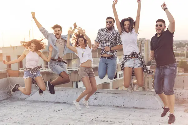 Bir Grup Genç Çatıdaki Bir Partide Eğleniyor Zıplıyor Ortadakilere Odaklan — Stok fotoğraf
