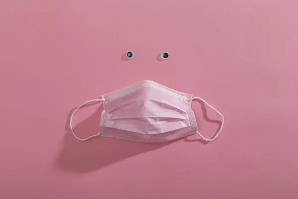 粉色外科护肤面罩顶部视图 在粉色背景下隔离 医疗面罩 作为防止Covid 19病毒爆发的防护设备的一部分 — 图库照片