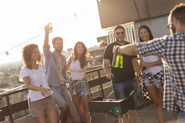 バーベキュー ビールを飲み 屋上パーティーで楽しむ暑い夏の日を楽しむ若い友人たち バーベキューの隣にいる人々に焦点を当てる — ストック写真