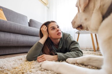 Güzel genç bir kadın evcil köpeğiyle evde dinleniyor.