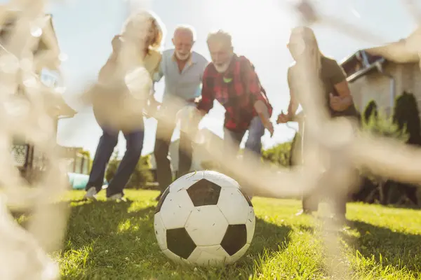 Группа Активных Пожилых Людей Веселится Играя Футбол Лужайке Заднем Дворе — стоковое фото