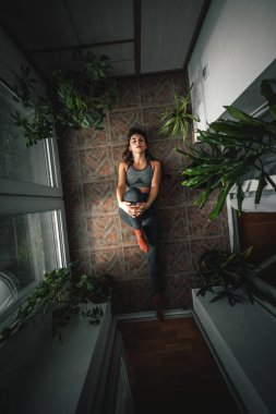 Spor giyimli güzel bir kadının sabahları evde egzersiz yaparken esnediği en güzel manzara.