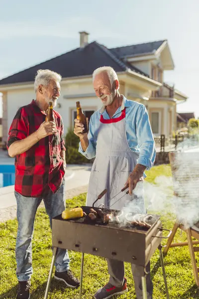 Dva Starší Muži Pijí Pivo Zatímco Grilují Maso Zahradní Grilovací — Stock fotografie