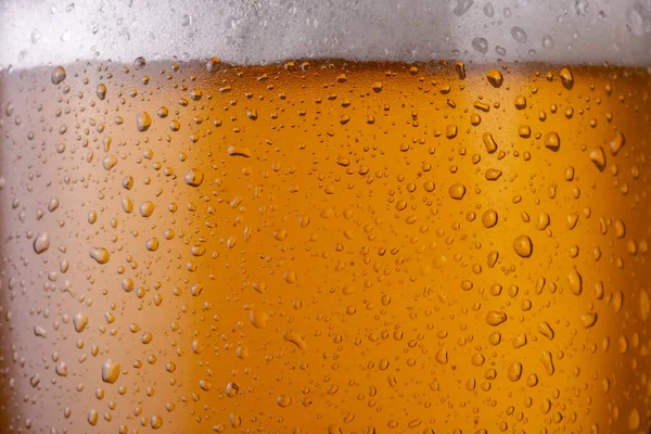 stock image Macro image of cold, wet beer glass with dew and condensate water droplets on the surface of the glass