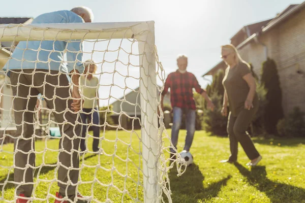 Bir Grup Aktif Yaşlı Insan Arka Bahçedeki Çimlerde Futbol Oynayarak — Stok fotoğraf