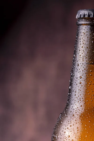 Detail of closed bottle of cold beer with dew and condensate water droplets on the surface of the glass