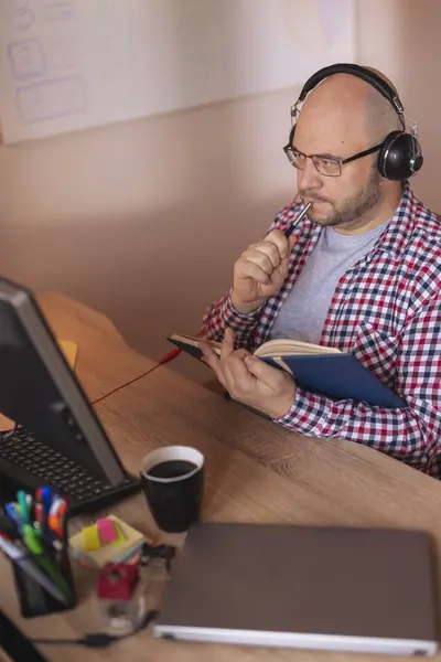 Man Wearing Headset Working Remotely Home Taking Notes Planner While — Stock Photo, Image