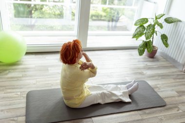 Aktif kıdemli kadın evde yoga eğitimi alıyor - sağlıklı ve aktif yaşam tarzı konsepti