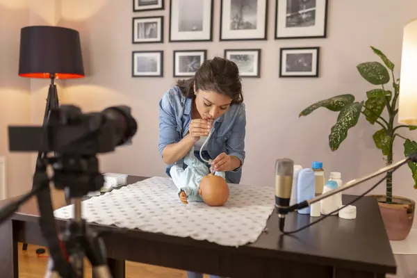 オンライン出生前のクラスコースの一部としてゴム吸引バルブとの新生児の鼻粘液吸引についての女性Voogger記録チュートリアル — ストック写真