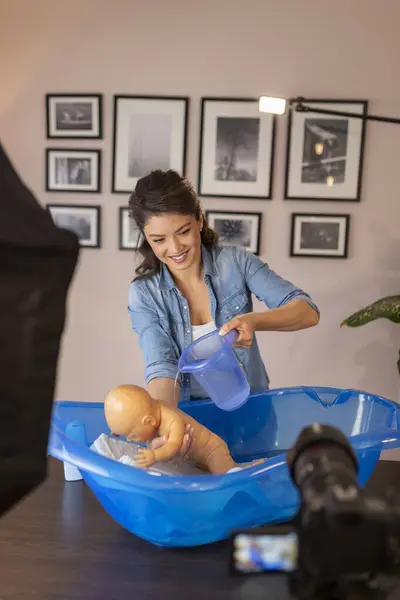 作为产前在线课程的一部分 女性吸血鬼记录了新生儿洗澡的视频 女性影响者拍摄了关于新生儿护理的教学 — 图库照片