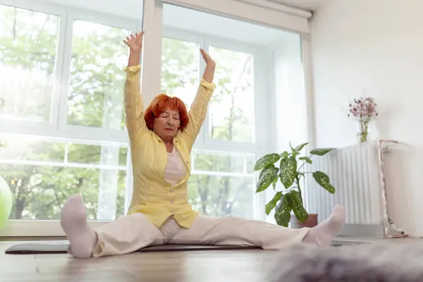 Active senior woman doing yoga training at home - healthy and active lifestyle concept