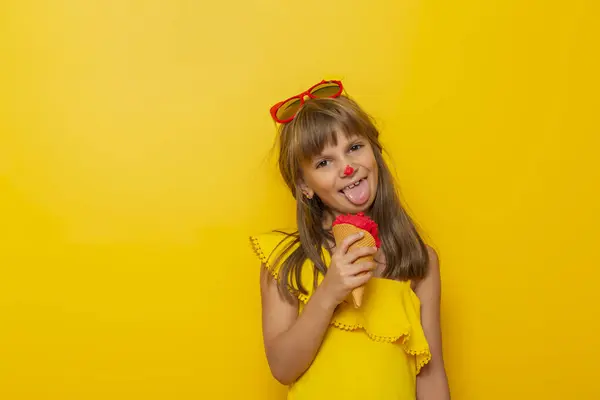 Mała Dziewczynka Bawiąca Się Podczas Jedzenia Lodów Stożku Odizolowanym Żółtym — Zdjęcie stockowe