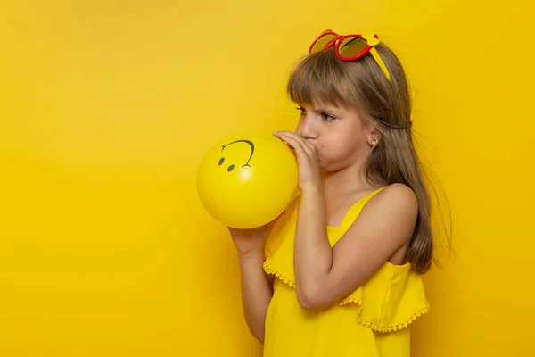 Mała Dziewczynka Zabawy Letnie Wakacje Dmuchanie Żółty Balon Izolowany Żółtym — Zdjęcie stockowe