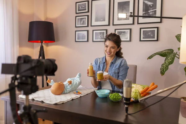作为网上产前课程的一部分 女博客记者拍摄了关于向婴儿营养介绍软食以及准备新鲜水果和蔬菜粥的视频 — 图库照片
