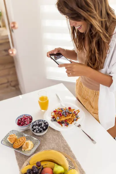 Güzel Bir Bayanın Kahvaltısını Evde Yaparken Rahatlarken Akıllı Telefon Kullanarak — Stok fotoğraf