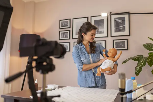 ダブルおむつと新生児の適切なヒップポジショニングに関するビデオを作る主婦 オンライン鳥の授業の一環として腰の機能不全を防ぐために — ストック写真
