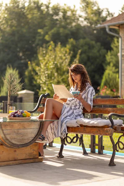 彼女の家の裏庭のテラスで朝食 新聞を読み コーヒーを飲んで 屋外で晴れた夏の朝を過ごす美しい若い女性 — ストック写真