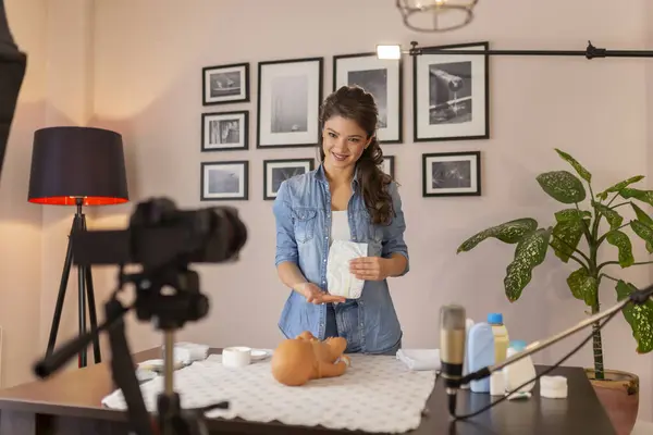 女性Vlogger拍摄有关更换新生儿尿布的视频 女性影响者在网上产前课程中讲授新生儿护理 — 图库照片