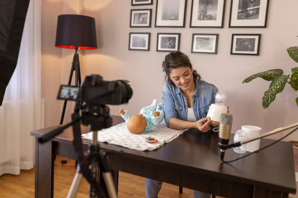 作为网上分娩班课程的一部分 女博客员录制了关于家用电器中婴儿奶瓶加热的视频 — 图库照片