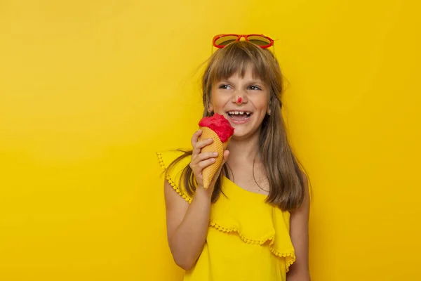 Mała Dziewczynka Bawiąca Się Podczas Jedzenia Lodów Stożku Odizolowanym Żółtym — Zdjęcie stockowe
