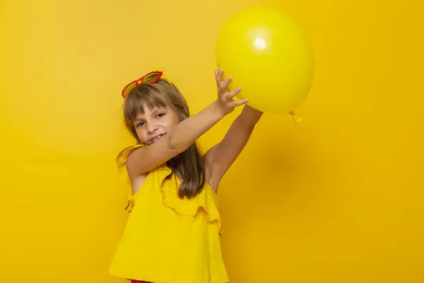 Mała Dziewczynka Zabawy Podczas Gry Żółtym Balonem Izolowane Żółtym Tle — Zdjęcie stockowe