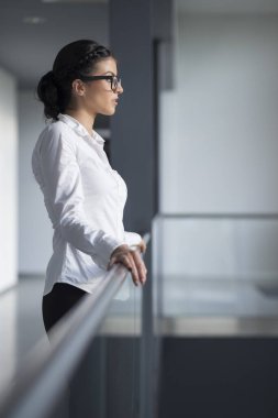 Güçlü, kendinden emin, iş kadını ofis koridorunda duruyor.