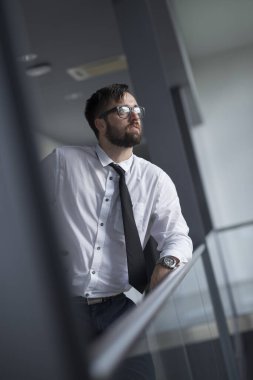Başarılı iş adamı bir ofis koridorunda mola verdi.