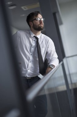 Başarılı iş adamı bir ofis koridorunda mola verdi.