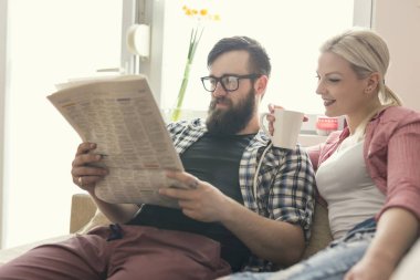 Birbirine aşık genç bir çift pencerenin yanındaki koltukta oturuyor, boş zamanlarının tadını çıkarıyor, gazete okuyor ve kahve içiyor. Pencere üzerinde parlaklık efekti