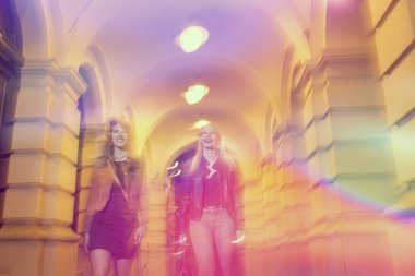 Şehir sokaklarında yürüyen iki kız, arkadaşlarıyla bir gece geçirmeye hazır.