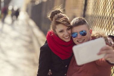 Güzel genç bir çift şehirde selfie çekiyor.