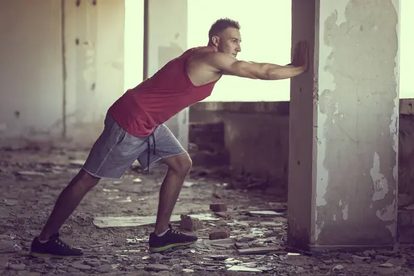 Spierachtige Atletische Gebouwd Jonge Man Uitrekken Een Ruïne Gebouw Voor — Stockfoto