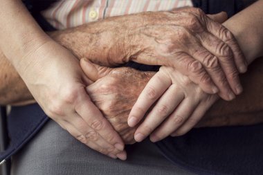 Yaşlı ve genç bir insanın el ele tutuşması. Yaşlı bakımı ve saygısı, seçici odaklanma