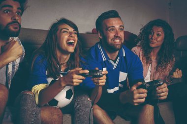 Futbol oynarken eğlenen bir grup genç arkadaş. Ortadaki adama odaklan.