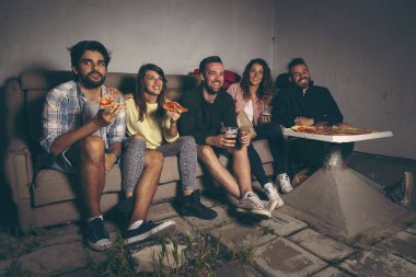 Bir grup genç arkadaş çatıdaki terasta film izliyor, pizza yiyor, bira içiyor ve eğleniyorlar.