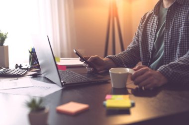 Akıllı bir telefonu tutan ve mesaj yazan bir erkeğin ellerinin ayrıntıları. Telefon tutan parmaklara odaklan.